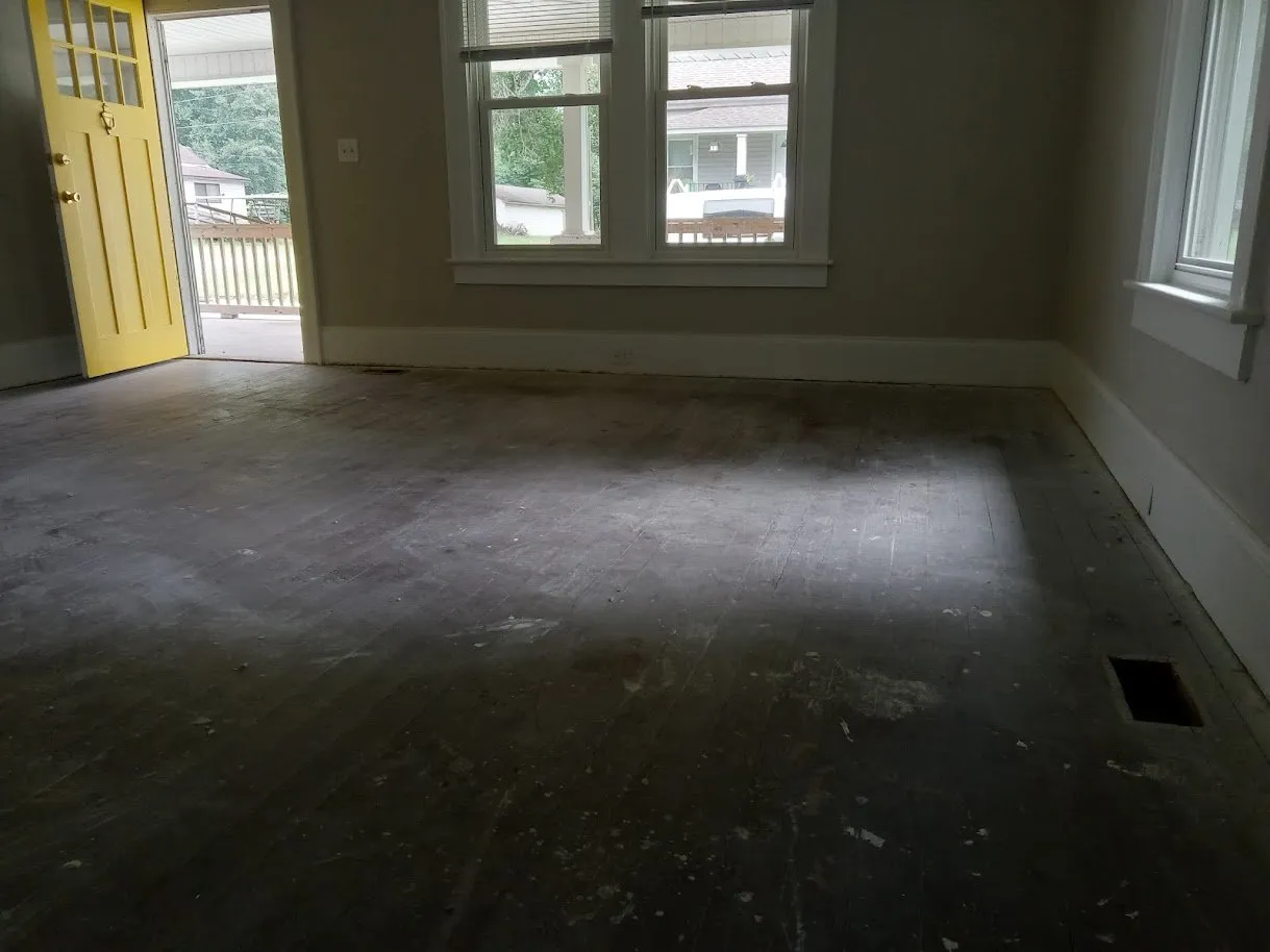 Before: the same heart pine floor covered in dark paint and old stain