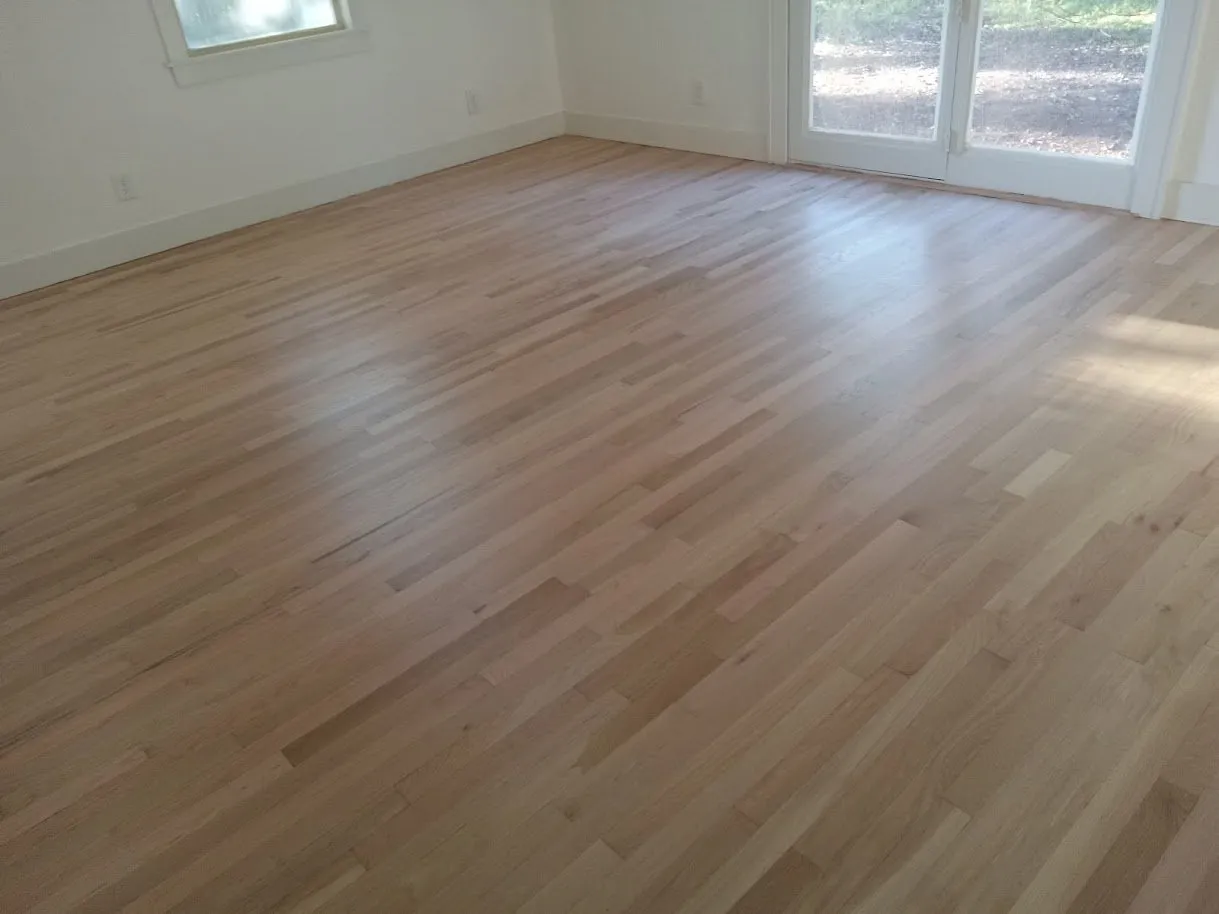 White oak floor refinished to a natural color in a bright room with French doors